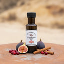 Fig Cinnamon Cranberry White Balsamic Vinegar bottle with figs, cranberries and cinnamon on terracotta surface