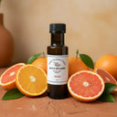 Orange White Balsamic Vinegar bottle with fresh oranges on terracotta surface