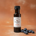 Blueberry White Balsamic Vinegar bottle with fresh blueberries on terracotta surface