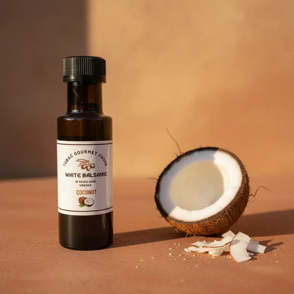 Coconut Aged White Balsamic Vinegar bottle with coconut on terracotta surface