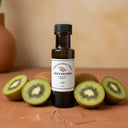 Kiwi White Balsamic Vinegar bottle with fresh kiwi on terracotta surface