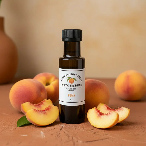 Peach White Balsamic Vinegar bottle with fresh peaches on terracotta surface