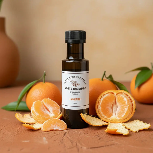 Tangerine Aged White Balsamic Vinegar bottle with fresh tangerines on terracotta surface