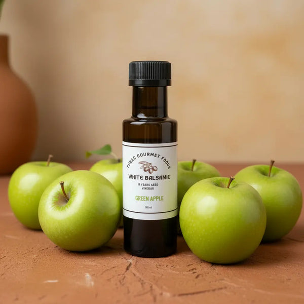 Green Apple White Balsamic Vinegar bottle with fresh green apples on terracotta surface