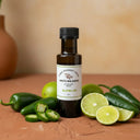 Jalapeno Lime White Balsamic Vinegar bottle with jalapeños and lime on terracotta surface