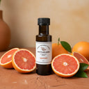 Grapefruit White Balsamic Vinegar bottle with fresh grapefruit on terracotta surface