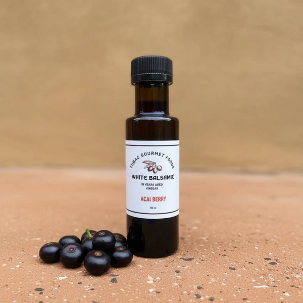 Acai Berry White Balsamic Vinegar bottle with acai berries on terracotta surface