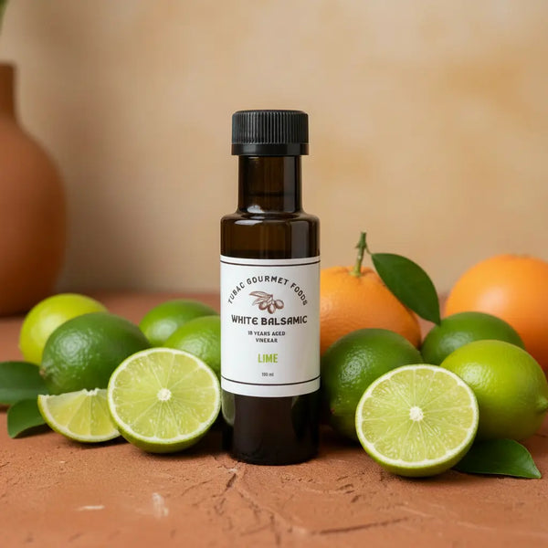 Lime White Balsamic Vinegar bottle with fresh limes on terracotta surface