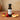 Strawberry Peach White Balsamic Vinegar bottle with fresh strawberries and peaches on terracotta surface