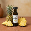 Pineapple Aged White Balsamic Vinegar bottle with fresh pineapple on terracotta surface