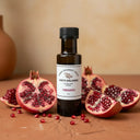 Pomegranate White Balsamic Vinegar bottle with fresh pomegranate on terracotta surface