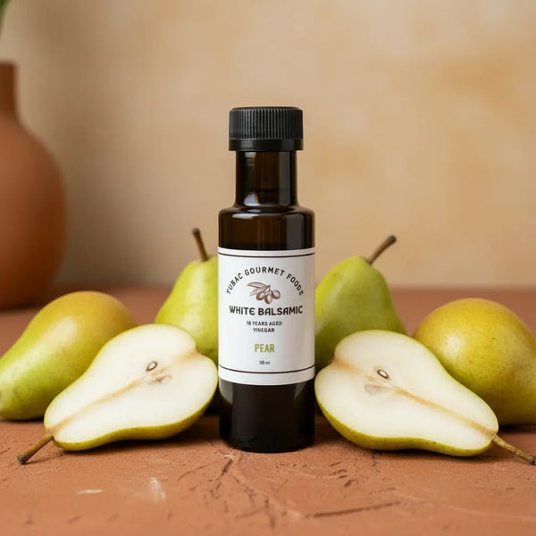 Pear White Balsamic Vinegar bottle with fresh pears on terracotta surface