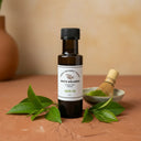 Green Tea White Balsamic Vinegar bottle with green tea leaves on terracotta surface