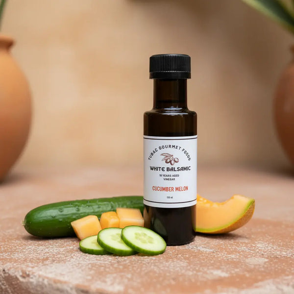 Cucumber Melon White Balsamic Vinegar bottle with cucumber and melon on terracotta surface