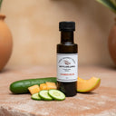 Cucumber Melon White Balsamic Vinegar bottle with cucumber and melon on terracotta surface