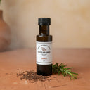 Smoked White Balsamic Vinegar bottle with wood chips on terracotta surface