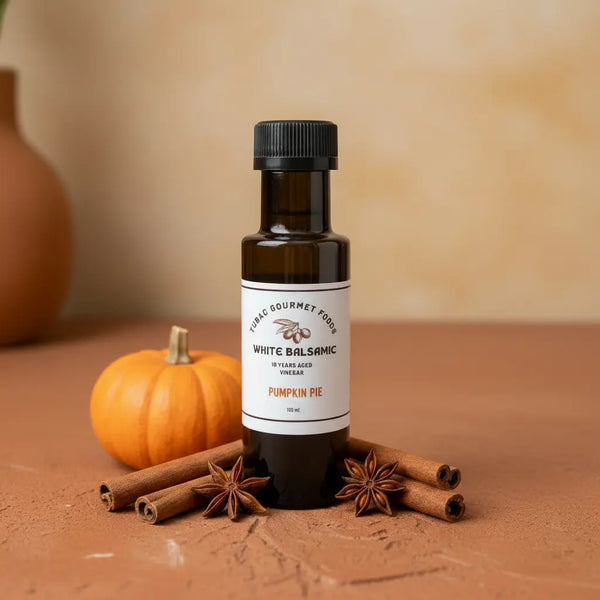 Pumpkin Pie White Balsamic Vinegar bottle with pumpkin and cinnamon sticks on terracotta surface