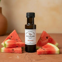 Watermelon White Balsamic Vinegar bottle with fresh watermelon on terracotta surface